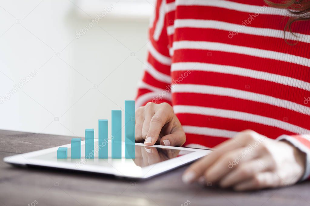 Woman analyzing graph on digital tablet