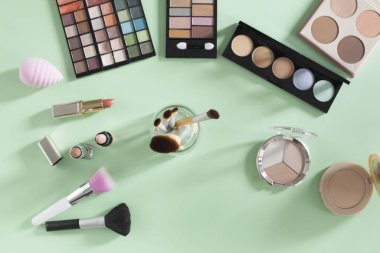Yumuşak yeşil arka planda makyaj ürünleri