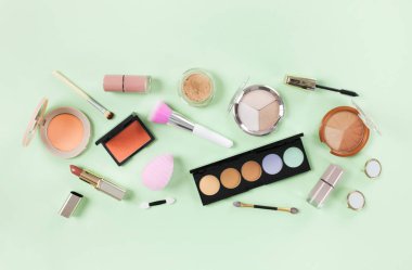 Yumuşak yeşil arka planda makyaj ürünleri