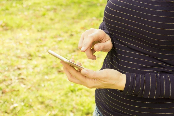 Kvinna som använder sin mobiltelefon utomhus — Stockfoto