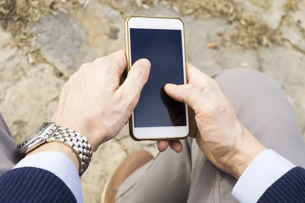 Messaggi di testo di un ragazzo nel parco sul suo smartphone — Foto Stock