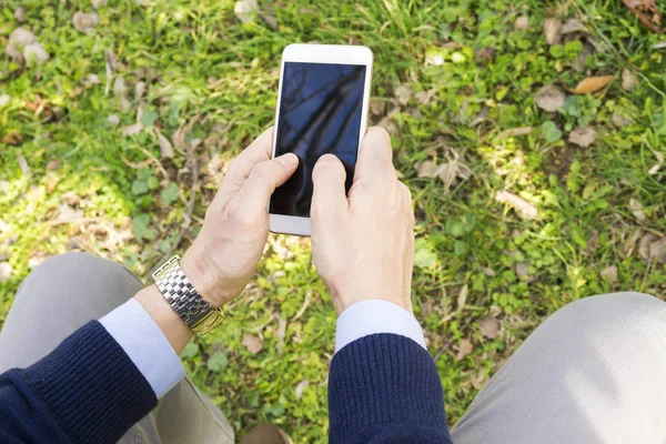 Messaggi di testo di un ragazzo nel parco sul suo smartphone — Foto Stock