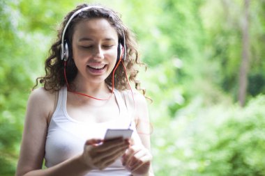 Akıllı telefondan müzik dinleyen genç kadın