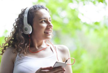 Akıllı telefondan müzik dinleyen genç kadın