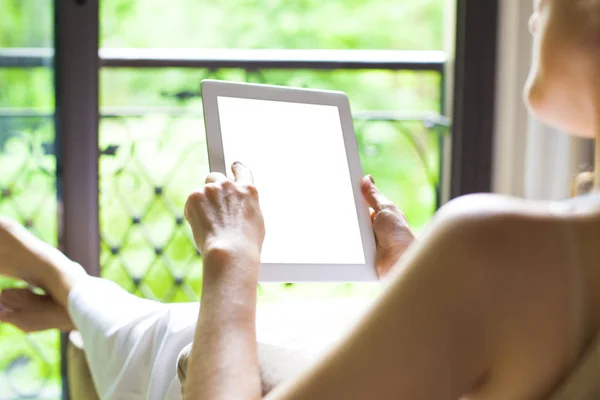 Woman using her tablet sitting on sof — Stock Photo, Image