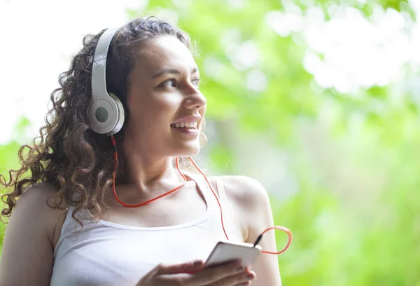 Akıllı telefondan müzik dinleyen genç kadın — Stok fotoğraf