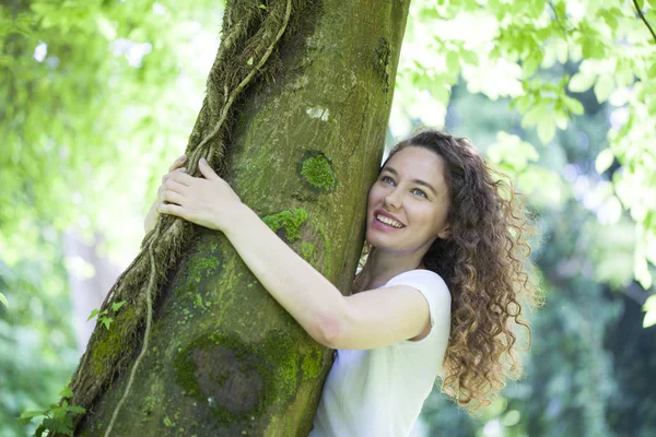 Νεαρή γυναίκα αγκαλιάζει το δέντρο — Φωτογραφία Αρχείου