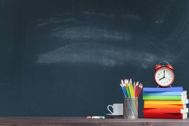 Okul öğretmeninin masasında kitap çalar saat