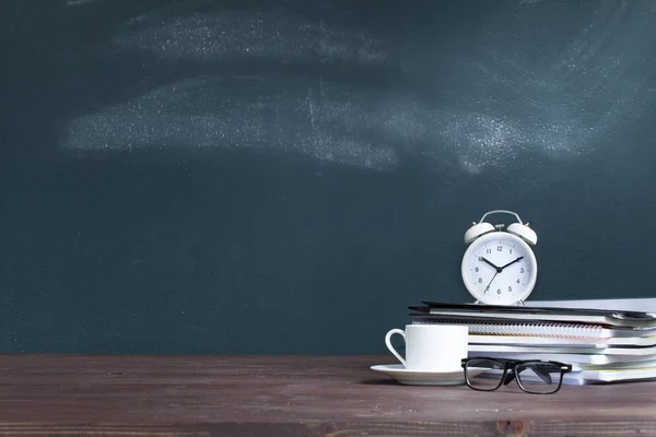 Okul öğretmeninin des notebooklar üzerinde çalar saat — Stok fotoğraf