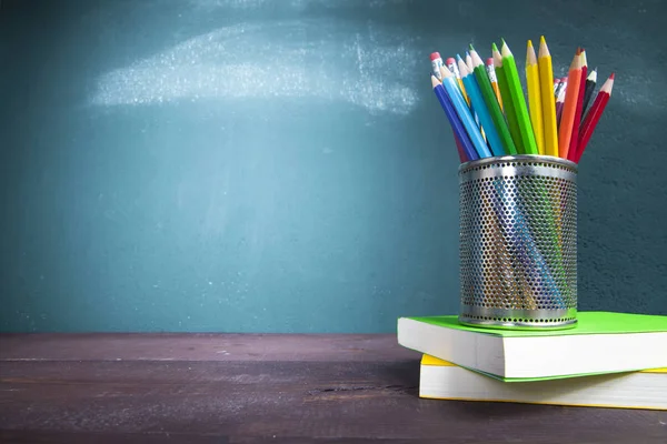 Ders kitapları ve kalemlik tahta ile okul masasında