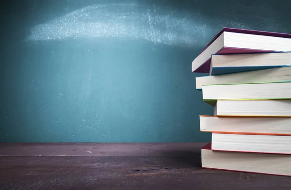 Schulbücher auf der Schulbank mit Tafel — Stockfoto