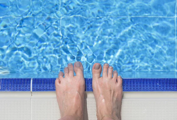 Bare feet over swimming pool