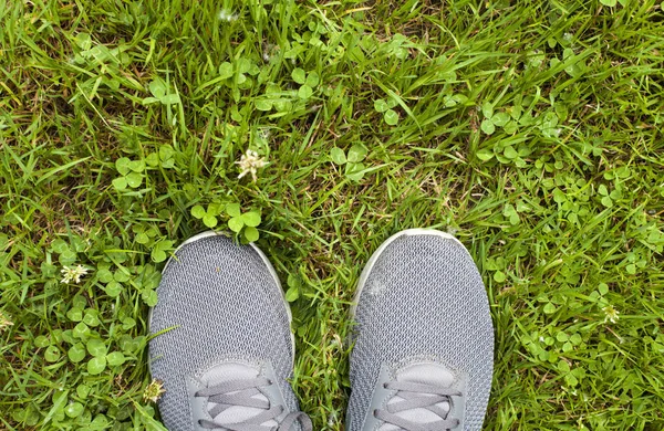 Jonge vrouw permanent in gras — Stockfoto