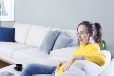 Hom kanepede hafta sonu oturan mutlu kadın