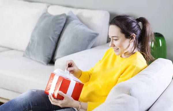 Vrouw opening haar cadeau bij hom — Stockfoto