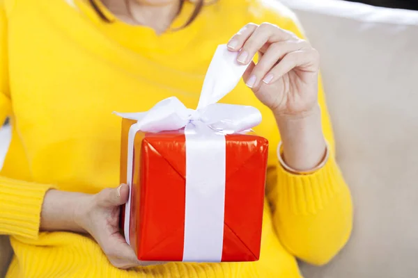 Vrouw opening haar cadeau bij hom — Stockfoto