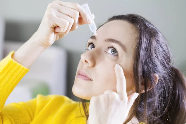 Nahaufnahme einer jungen Frau, die Augentropfen aufträgt, künstliche Tränen. — Stockfoto