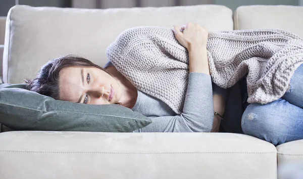 Jonge vrouw lijdt PMS pijn in bed — Stockfoto