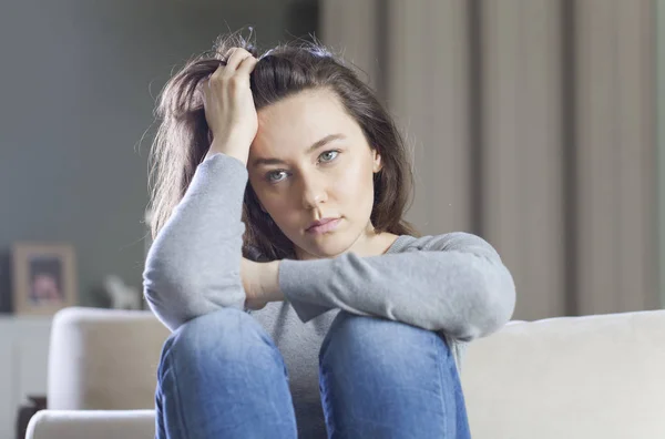 Депресивна молода жінка на дивані вдома — стокове фото