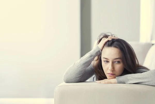 Depressed young woman on sofa at hom — Stock Photo, Image