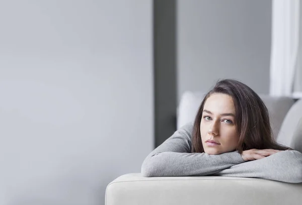 Depresso giovane donna sul divano a hom — Foto Stock