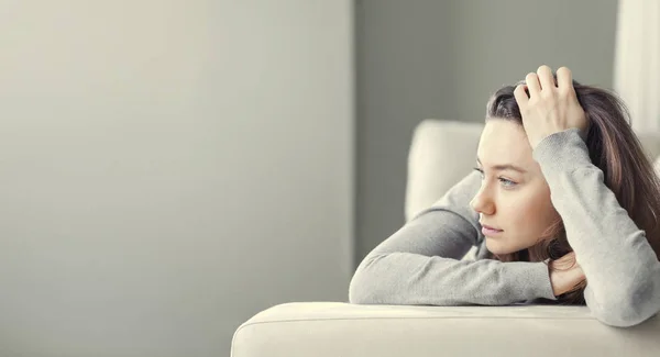 Depressed young woman on sofa at hom — Stock Photo, Image