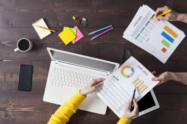 Ofiste masa başında çalışan iki kişi. Tepeden çekim.