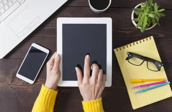 Woman hands holding digital tablet at wooden office desktop, top — Stock Photo, Image