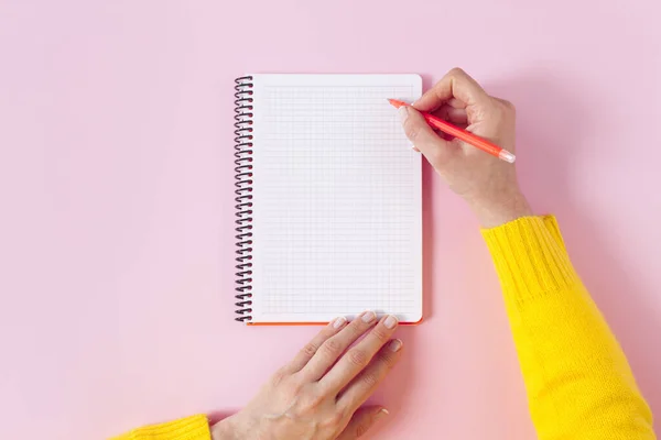 Escritura a mano femenina en un bloc de notas en espiral en blanco. Burla para el diseño — Foto de Stock