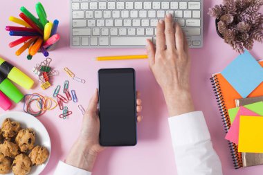 Ofis masasında çalışan bir kadın. Üst görünüm pembe moda ofis masası