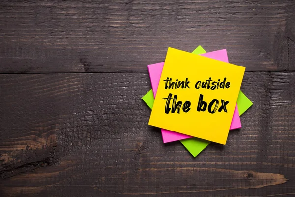 Multi-colored stickers with Think Outside The Box message on woo — Stock Photo, Image