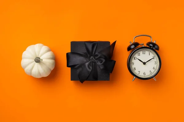 ブラックギフトボックス クロックとカボチャ オレンジの背景に感謝祭と黒の金曜日の販売の概念 — ストック写真