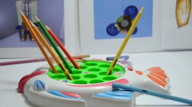 Tasarımcı stüdyosunda dönen renkli kalemler, yakın plan.