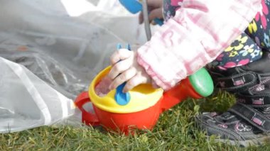 Dışarıda plastik oyuncaklarla oynayan bir kız.