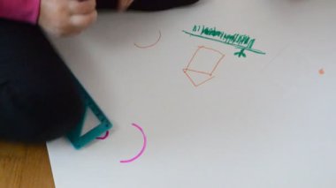 Baba ve kızı kağıda çiziyor.