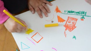 Baba ve kızı kağıda çiziyor.