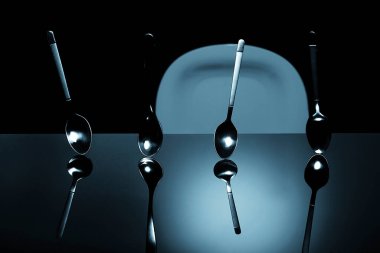 Siyah bir masada kaşıklar. 