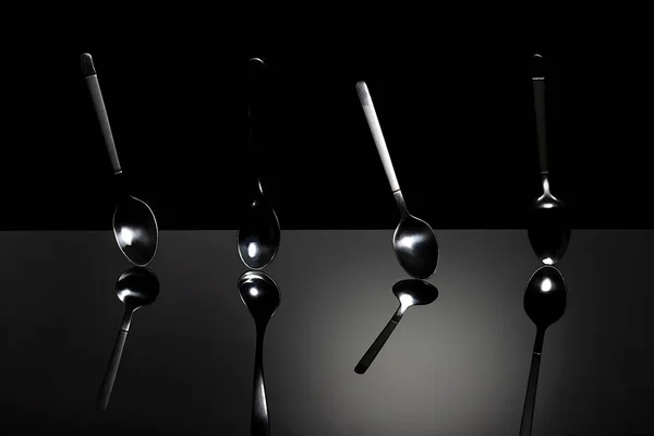 Κουτάλια σε μαύρο τραπέζι . — Φωτογραφία Αρχείου