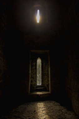 Gün batımı ışığı Irel 'deki bir kilisenin penceresinden geliyor.