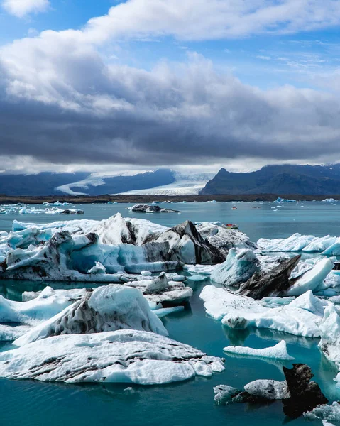 在冰岛的一个泻湖中漂浮的船只和冰山 — 图库照片