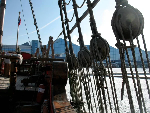 A sailing ship stands near the shore in winter