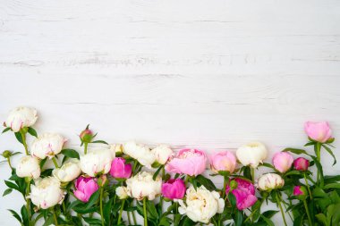Beyaz ahşap zemin üzerinde beyaz ve pembe peonies buket. Tatil arka plan, kopya alanı, üstten görünüm. Anneler günü, Sevgililer günü, Doğum günü kavramı.
