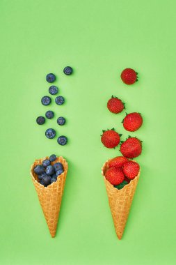 Dondurma külahı yeşil zemin üzerine yaz meyveleri. Çilek ve böğürtlen koni. Görünümü en çok, uzay kopyalayın. Yaz konsepti, Minimalizm.
