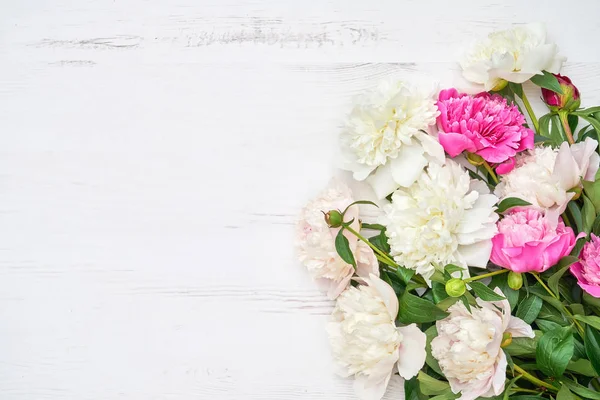 Beyaz ahşap zemin üzerinde beyaz ve pembe peonies buket. Alan, üstten görünüm kopyalayın. Anneler günü, Sevgililer günü, Doğum günü kavramı. Tebrik kartı.