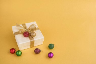 Hediye veya altın şerit ve Noel dekorasyonu altın arka plan üzerinde mevcut kutusu. Görünümü en çok, uzay kopyalayın. Noel tebrik kartı.