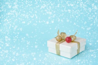 Beyaz hediye veya mevcut kutu mavi arka plan, kar doku üzerinde Noel dekorasyonu ile. Tebrik kartı. Kopya alanı.