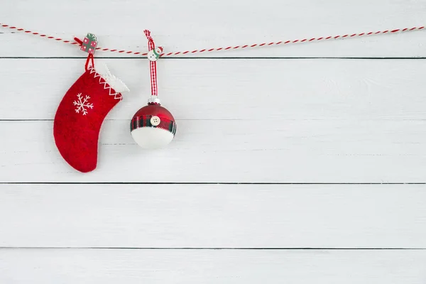 Red Christmas ornaments on white wooden background. Red Christmas sock with decoration. Copy space