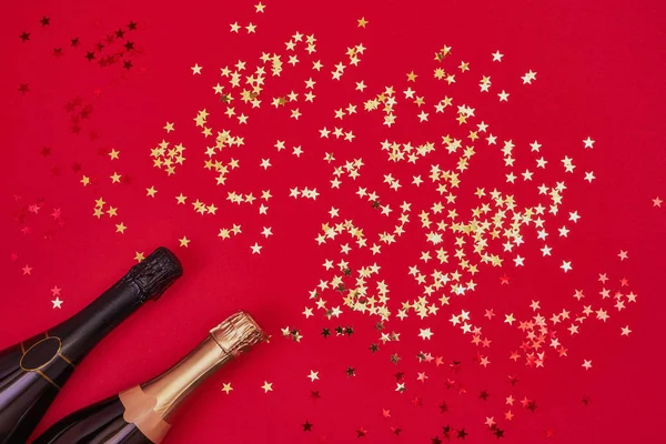 Dos Botellas Champán Con Confeti Dorado Sobre Fondo Rojo Piso — Foto de Stock