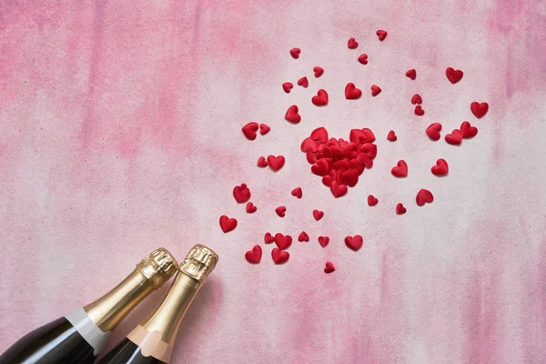 Duas Garrafas Champanhe Com Corações Vermelhos Fundo Rosa Espaço Cópia — Fotografia de Stock