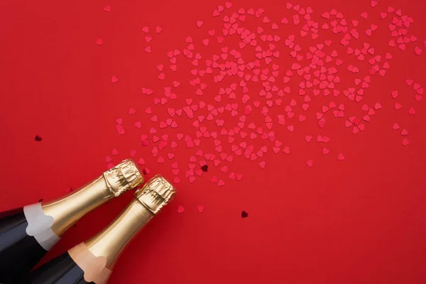 Botellas Champán Con Corazones Confeti Sobre Fondo Rojo Espacio Copia — Foto de Stock